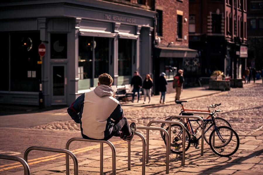 placemaking photography. manchester. norther quarter. architecture. man sits on bike racks