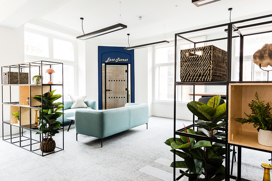 modernised open plan office space. shelves with plans and ornaments.