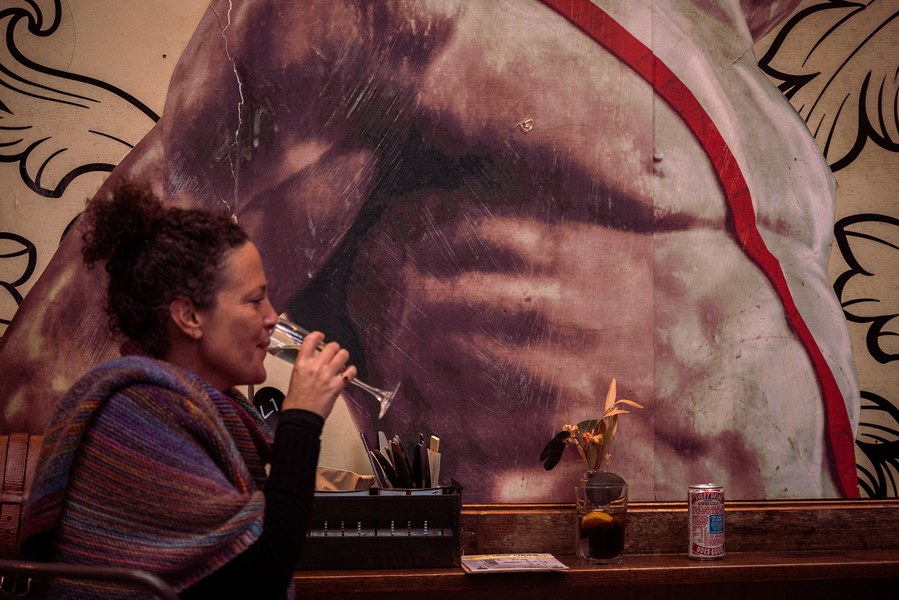 placemaking photography. manchester. norther quarter. architecture. customer sits in front of street art drinking wine