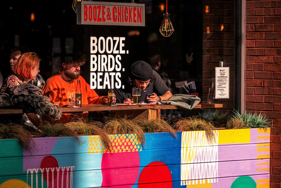 placemaking photography. manchester. norther quarter. group of friends sitting in window of bar