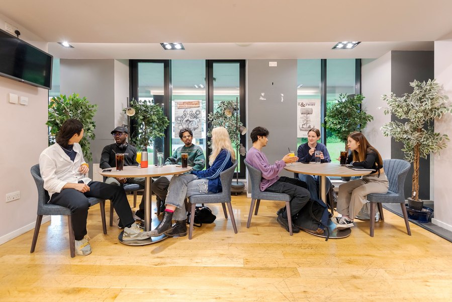 student lifestyle photography, group of students sat in campus bar enjoying drinks