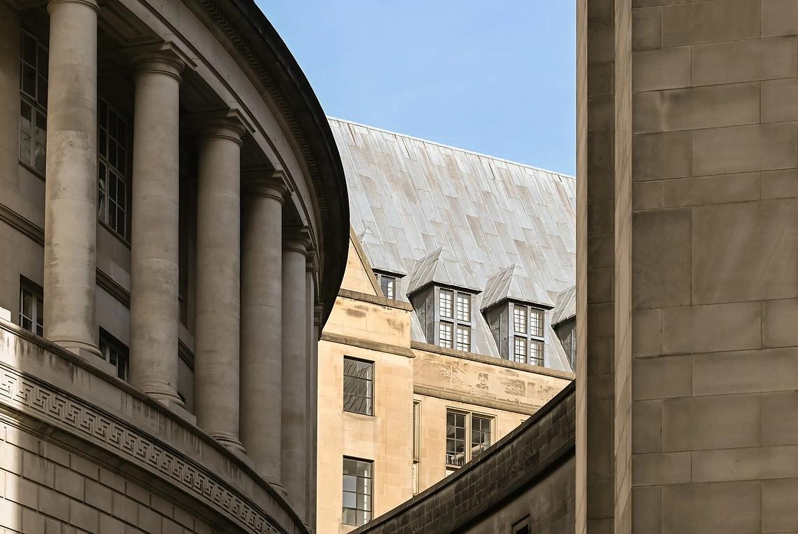 Manchester City centre architecture shows central library and town hall against a blue sky