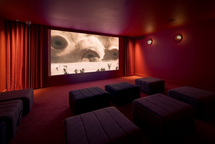 cinema room with low lighting and red walls