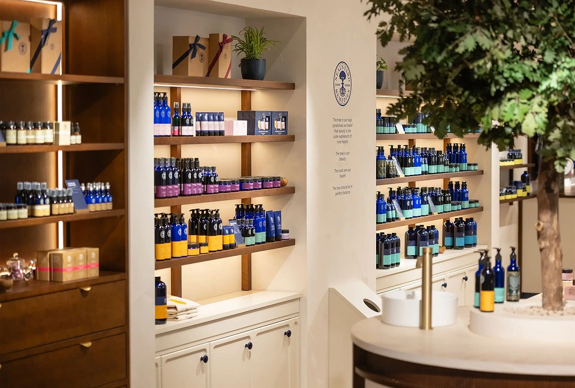 Interior retail photography showing the central preserved oak tree feature inside Neal's Yard Manchester.