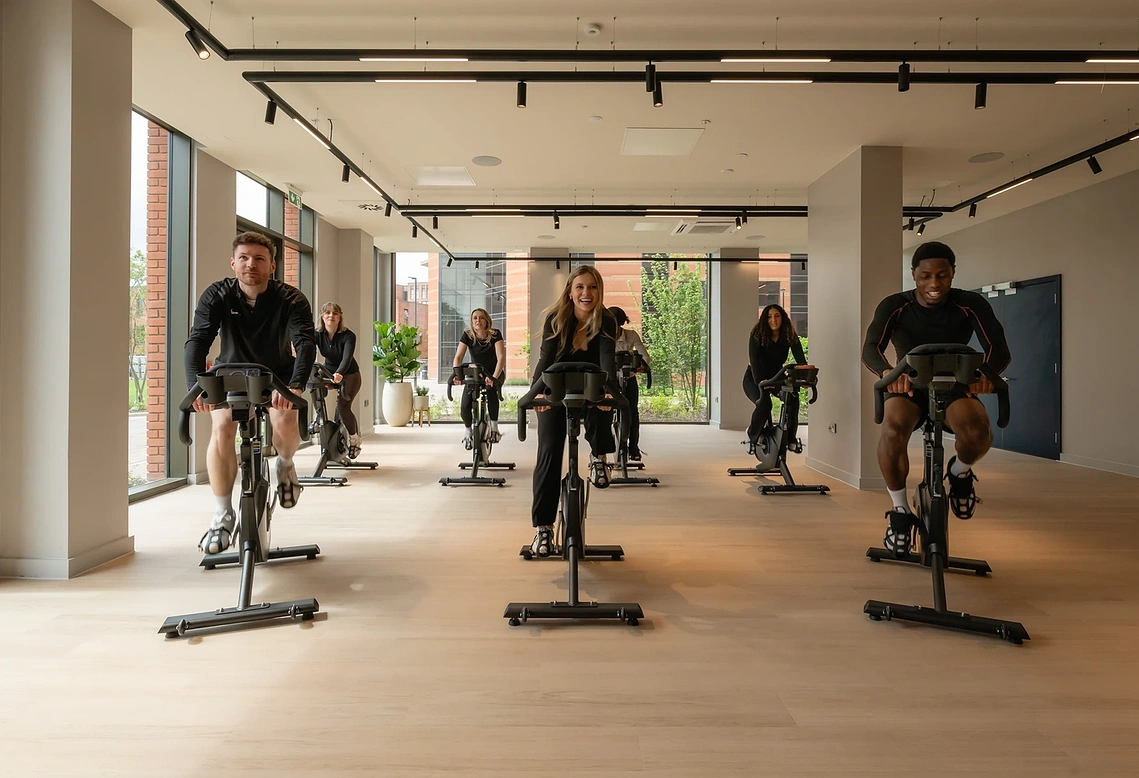 Residents in a spin class in Podium's wellness studio, Old Trafford. Commercial lifestyle photography for J2.