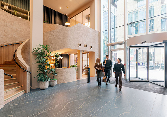 Commercial lifestyle photography for Manchester building shows workers arriving through doors into reception area