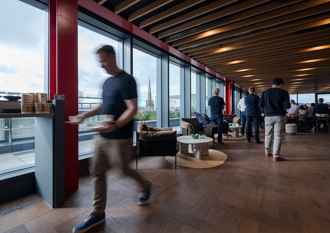 interiors photography showing a modern space with people at a corporate social event, slatted ceiling