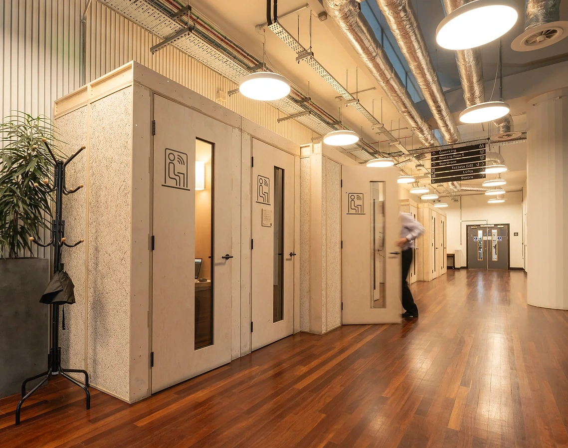 Sustainable office fitout photography showing U-Build meeting pods in use inside a Manchester climate-tech hub. 