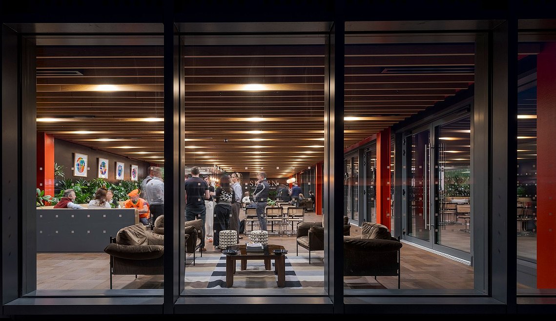architecture photograophy of an open plan social space in a modern building, shot from outside and looking in