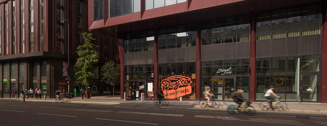 Manchester Oxford road, circle square, cyclists, vibrant everyday moments in an architect-designed space.	commercial lifestyle photography for architects Manchester