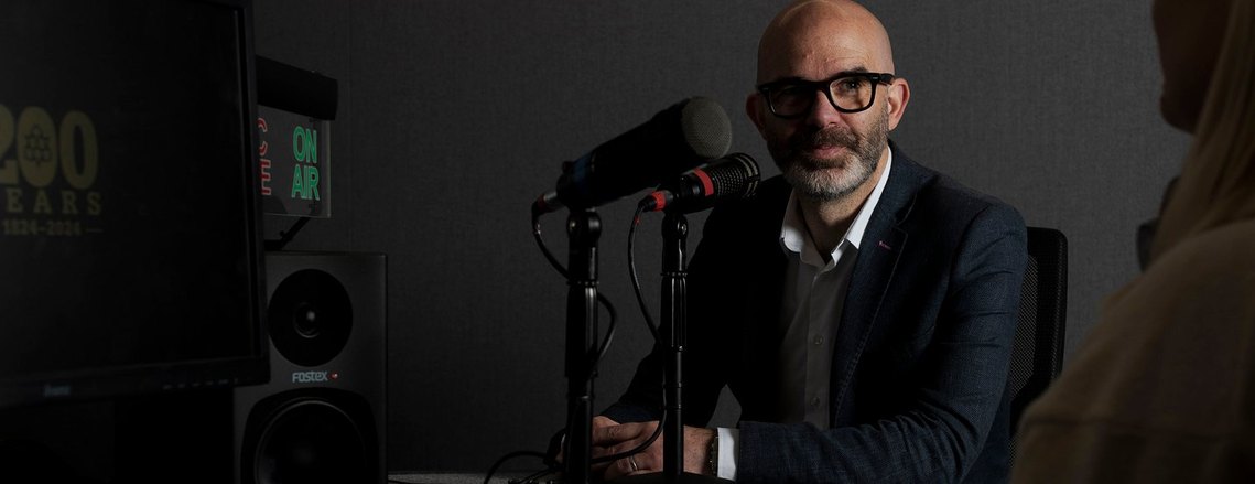 subject sat in radio studio with mic on table