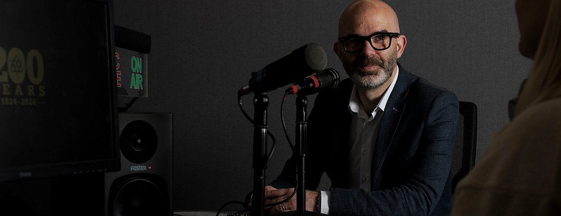 subject sat in radio studio with mic on table