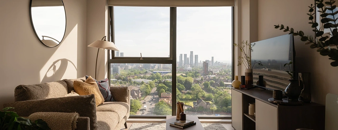 Podium show apartment living room in natural light, looking towards the Manchester city centre skyline from Old Trafford.
