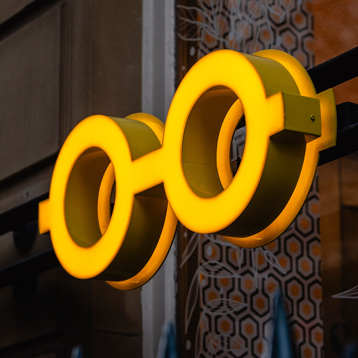 close up of illuminated glasses logo displayed outside optician window