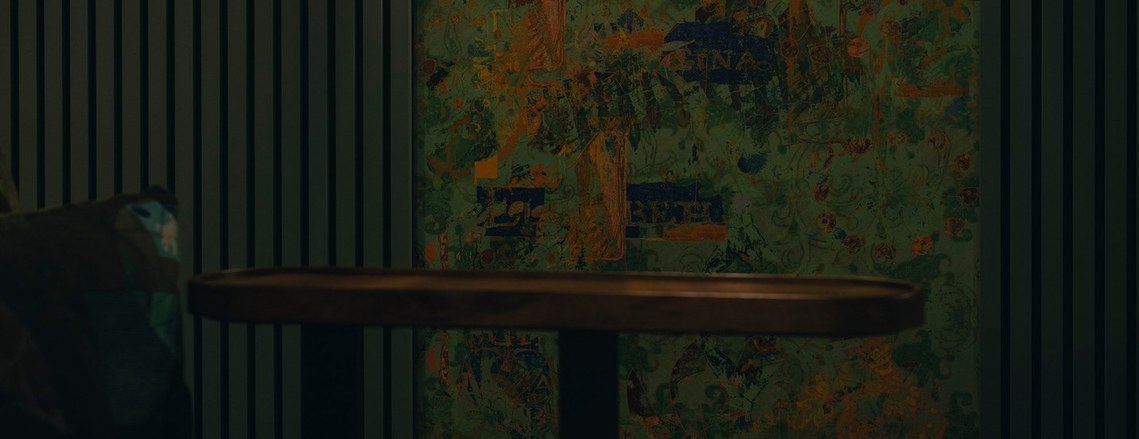 cropped photo of cinema seating and patterned wall covering all with hues of green