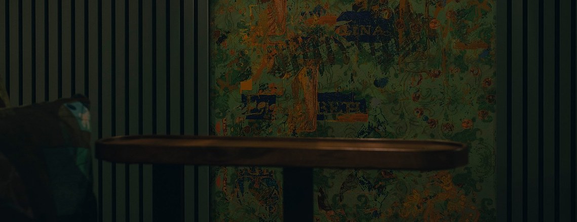 cropped photo of cinema seating and patterned wall covering all with hues of green