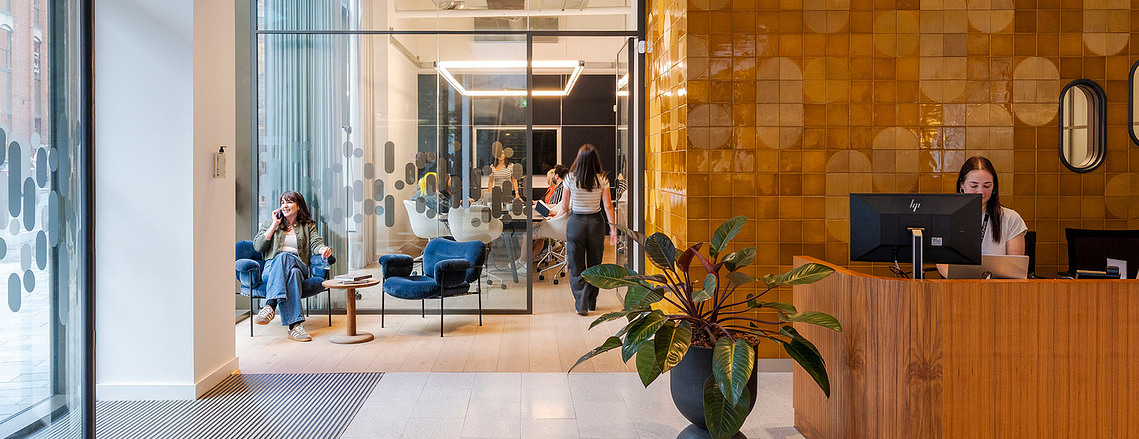 Authentic lifestyle photography at Clockwise Manchester workspace. Mid-century interiors, reception desk, meeting room, professional environment
