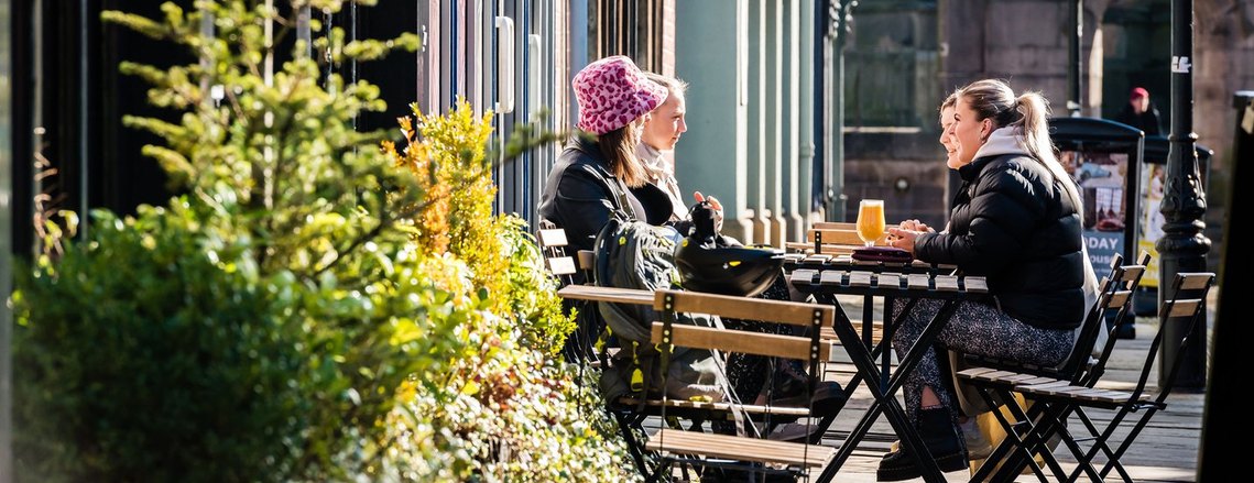 stockport lifestyle photography, customers sitting at table outside a cafe in morning sunshine