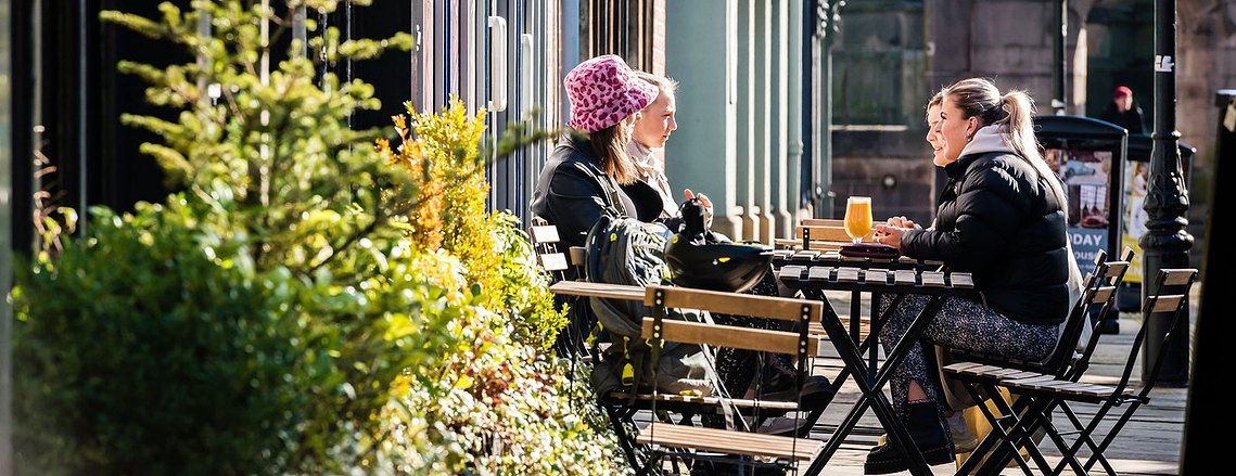 stockport lifestyle photography, customers sitting at table outside a cafe in morning sunshine
