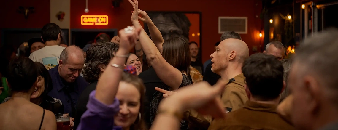 Documentary lifestyle photographer capturing authentic social interactions at a club night venue in Stretford.
