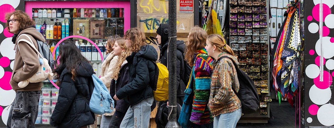 architecture and lifestyle photography, group of people walking past bright and busy shop, urban scene, 
