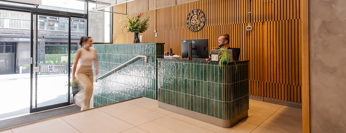 Commercial interiors photographer capturing workspace design details for Clockwise brand photography. Entrance way to building with tiles and wood cladding