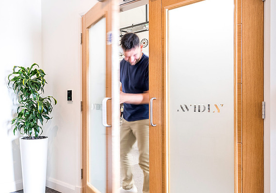 Case Study Photography Cover For Marketing And Brand Photography For Lancashire Agency, Avidly Uk showing a worker walking through branded door