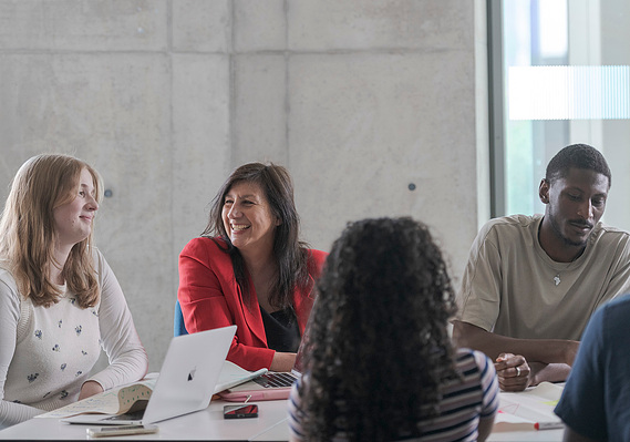 Marketing photography case study cover for Manchester Metropolitan University  showing a tutor with students engaged in a discussion
