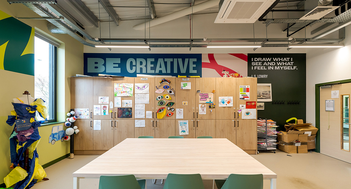 Architectural vinyl photography showcasing custom wall graphics and inspirational quotes installed on a commercial interior wall. A live space with clutter