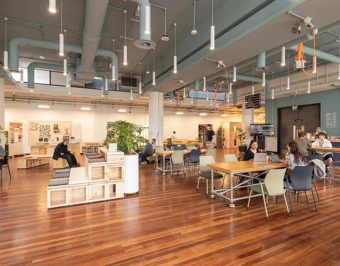 Sustainable office fitout photography wide shot of shared working space in Manchester climate-tech hub. 