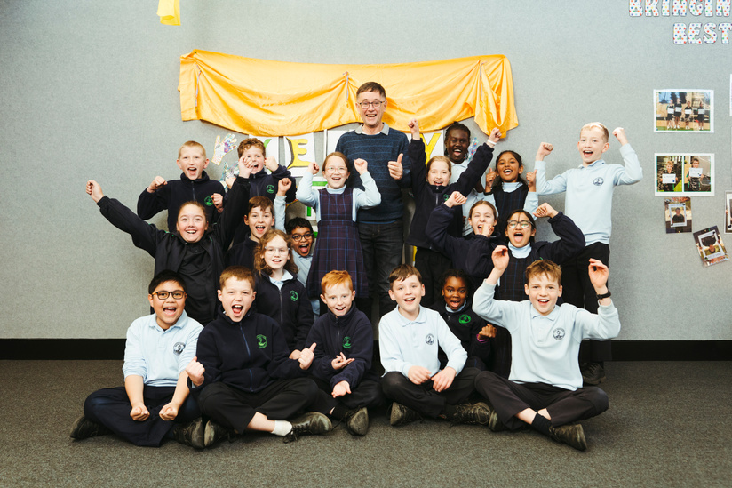 Good Shepherd Catholic Primary School teacher Keith Roberts, father of Olympic javelin thrower Kelsey-Lee Barber, with students show their support as she throws in the final on Friday night. Picture: Dion Georgopoulos - THE CANBERRA TIMES, ACM
