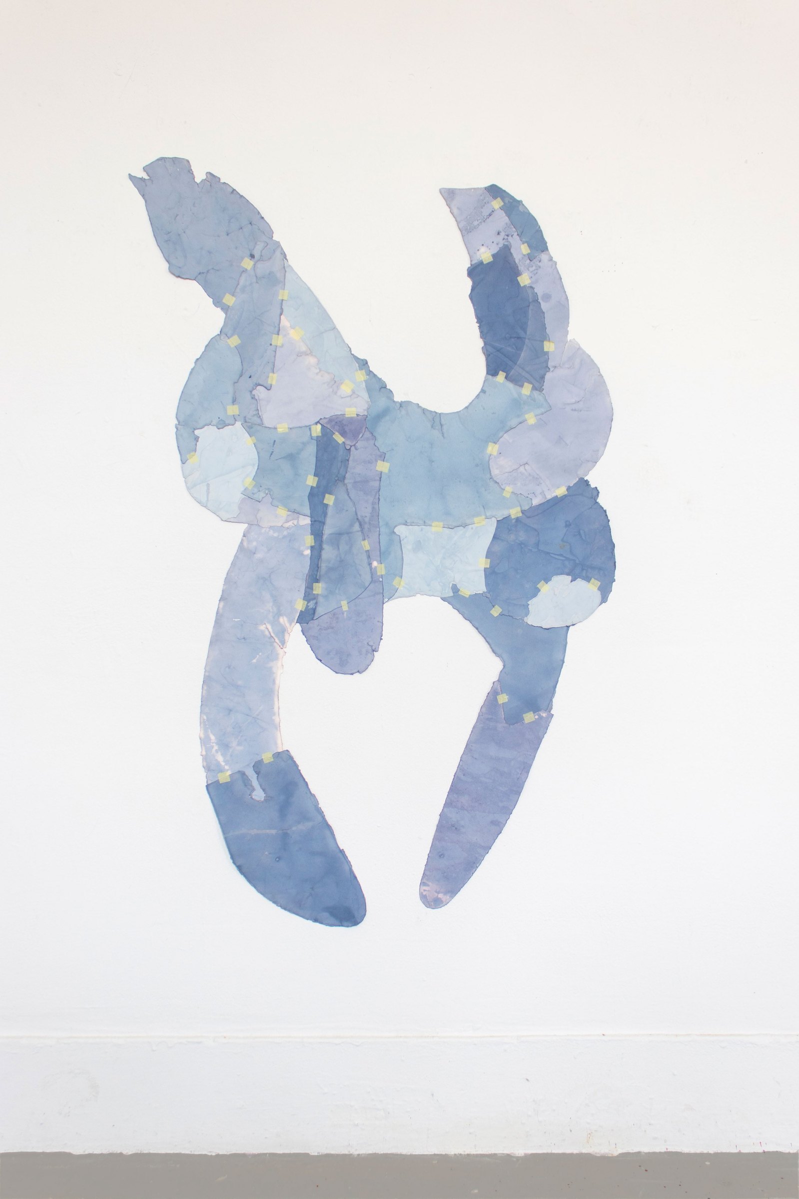 Jumping figure made from paper object hanging on a wall. Jamie Kane
