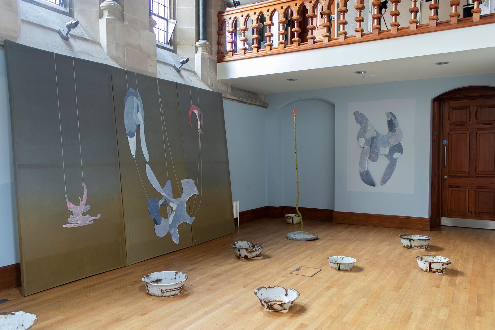 Blue curved chapel with painting and sculpture. Green fabric and metal bowls. Jamie Kane