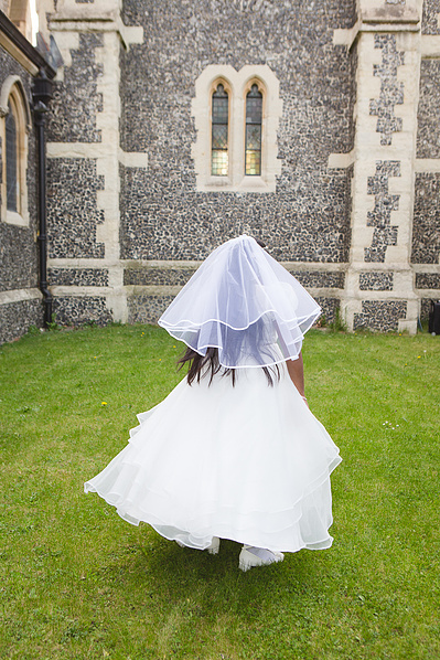 Candid family moment after a First Holy Communion ceremony, taken in West Essex. Professional Holy Communion portraits and reportage photography available in London and nearby locations