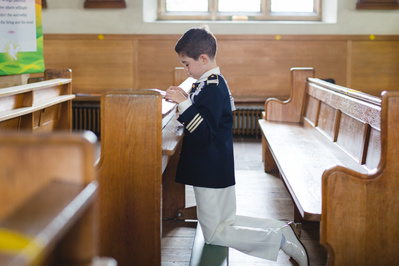 Candid family moment after a First Holy Communion ceremony, taken in West Essex. Professional Holy Communion portraits and reportage photography available in London and nearby locations