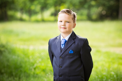 Natural light portrait of a boy on his First Holy Communion day, photographed in North East London. Specialising in Holy Communion photography for families across London and surrounding areas.