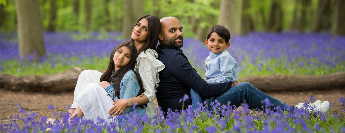 Family during a Bluebell child & family portrait session in North East London, seated in the forest surrounded by bluebells. 
Little Bunny Photography - Maternity Child and Family Photos  in Woodford Epping Wanstead London.  #bluebellphotoshootLondon 