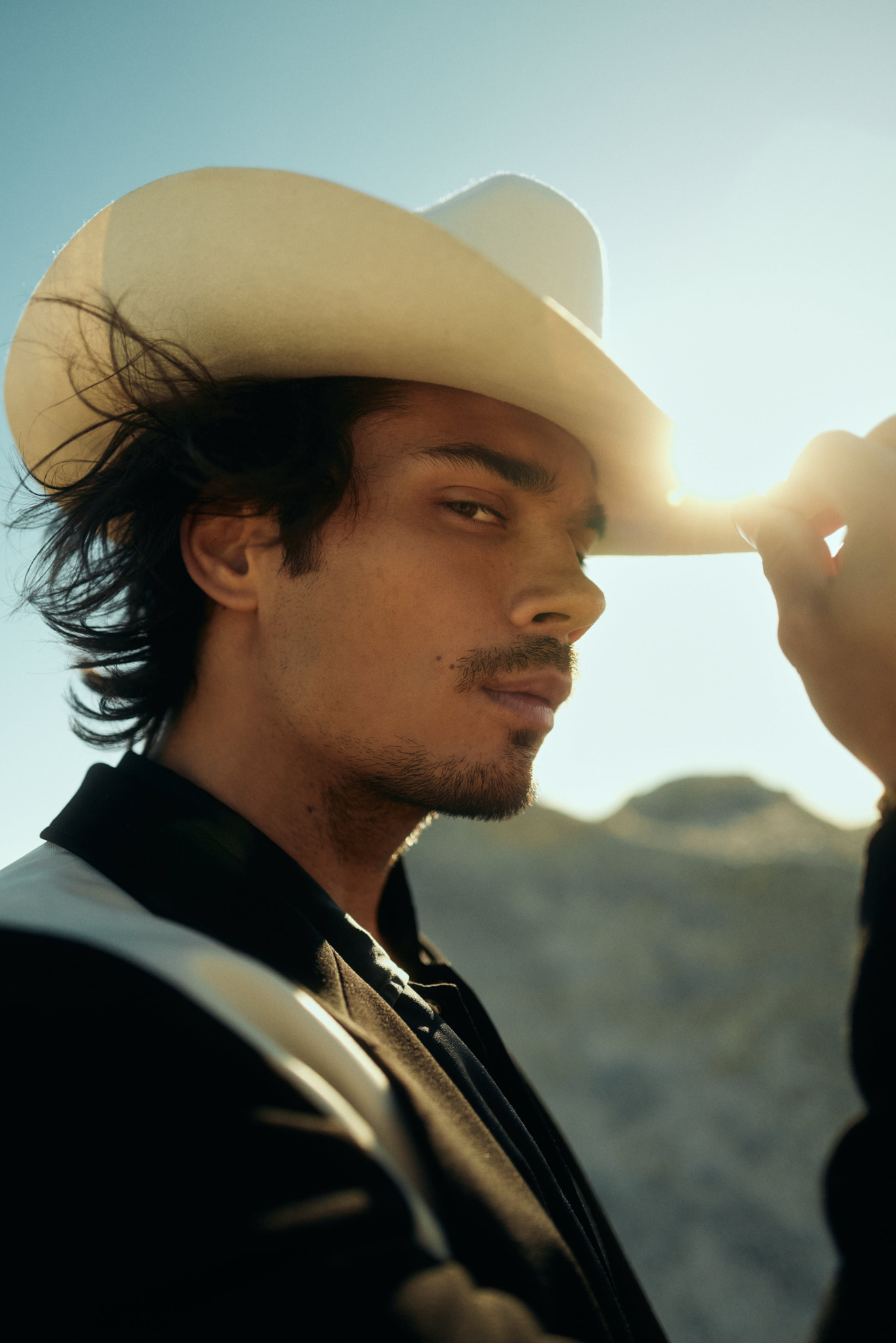 Drew Ray Tanner from CW Riverdale wearing a cowboy hat in the desert