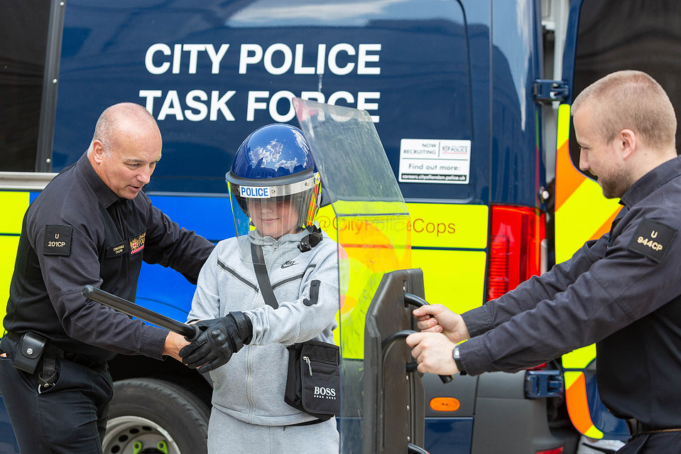City of London Police give a demonstration of riot gear to a young boy