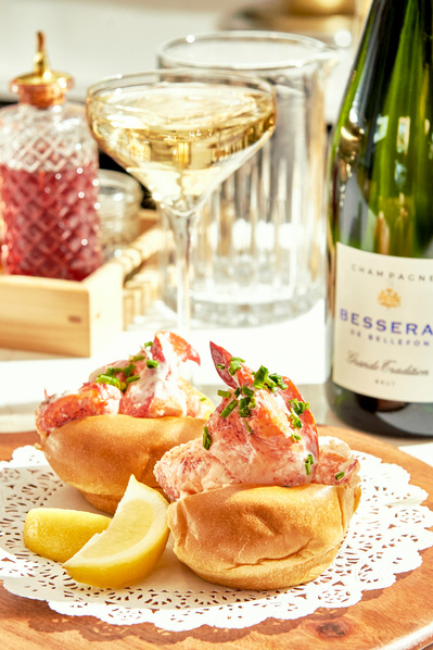 lobster roll at fine dining restaurant with glass and bottle of champagne