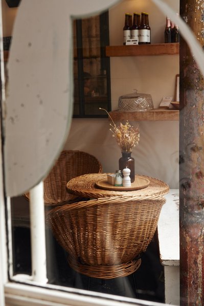 Parisian cafe with wicker chairs seen through glass window