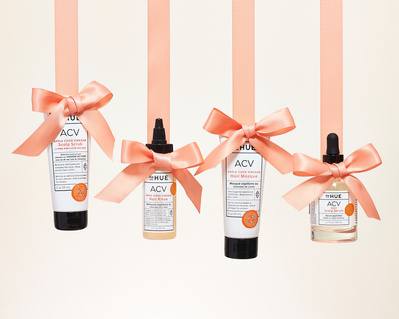 holiday campaign image with DP Hue haircare products and pink orange ribbon