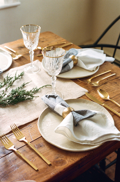 editorial tablescape with napkins and crystal wine glasses on rustic wooden table