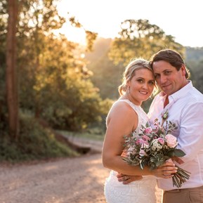 Backlit image with bride and groom leaning into each other on country road near Eudlo, Sunshine Coast hinterland.