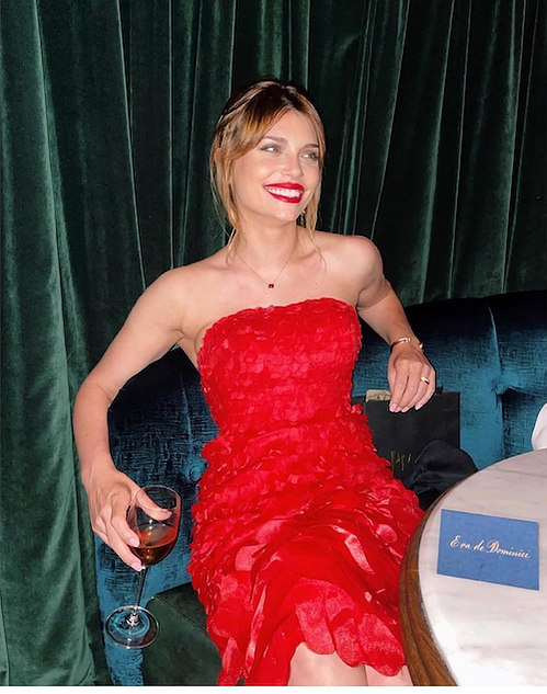 Eva de Dominici is wearing a red strapless dress at an event associated with Piaget, a luxury watch and jewelry company. Dress by Oliver Tolentinto
Stylist Jennifer Féin