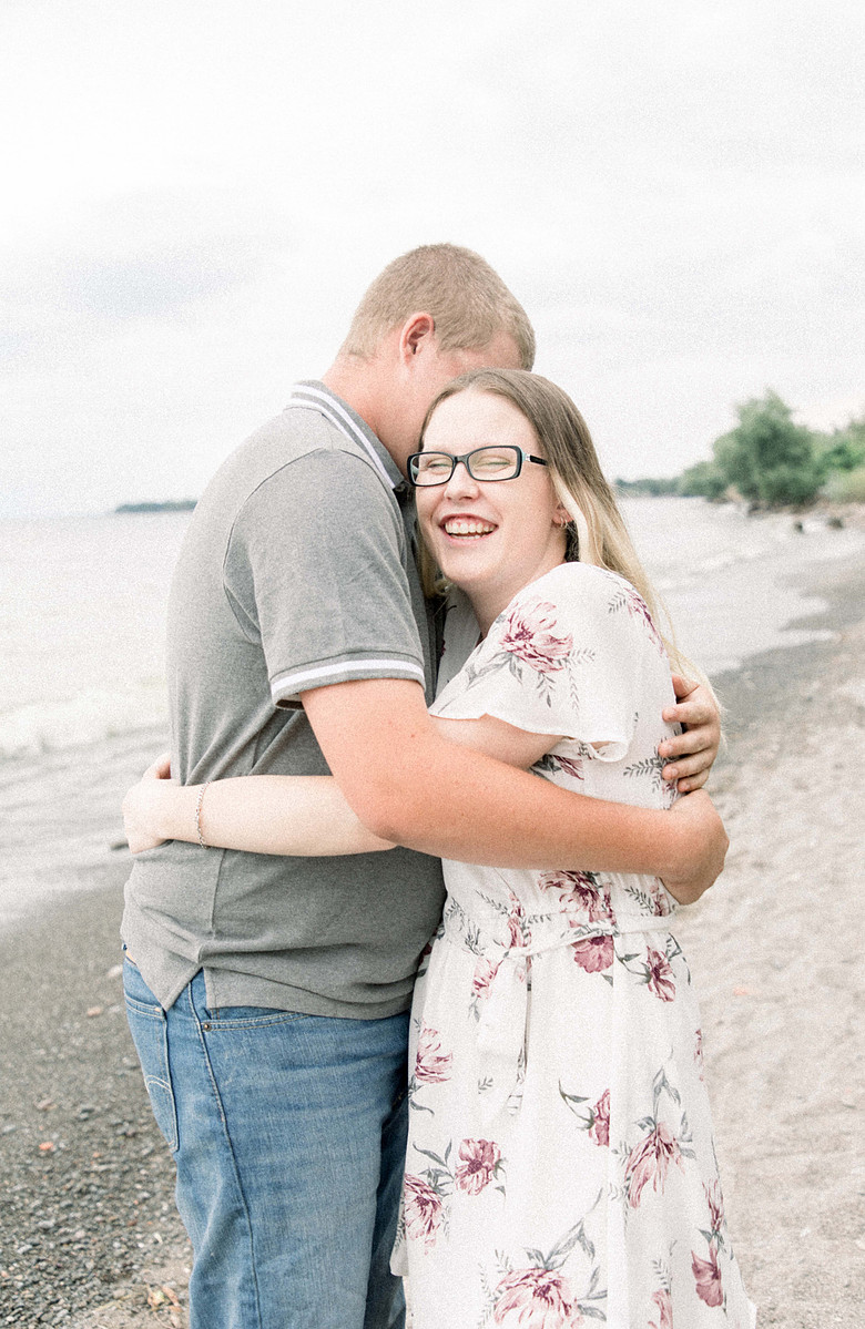 Candid portrait of couple hugging and laughing on the beach, Emily VanderBeek Photography, Portrait and Family photography, Niagara Photographer, Champlain Photographer, Vaudreuil-Soulanges Photographer, candid photography, authentic photography.