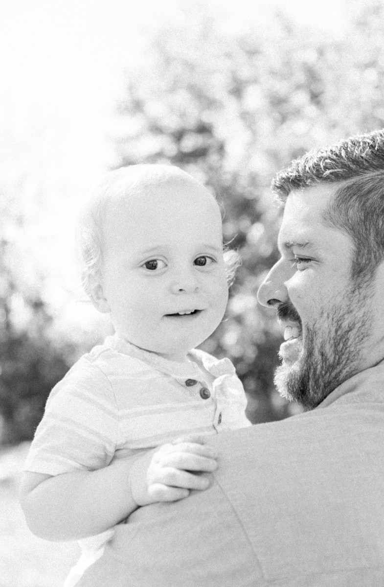 Candid portrait father and son with son smiling at the camera, Emily VanderBeek Photography, Portrait and Family photography, Niagara Photographer, Champlain Photographer, Vaudreuil-Soulanges Photographer, candid photography, authentic photography.