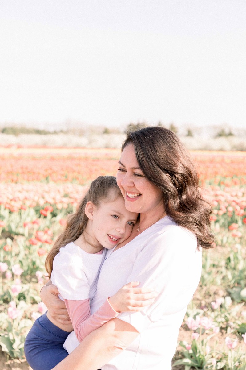 Candid portrait of mother holding little girl in a tulip field, Emily VanderBeek Photography, Portrait and Family photography, Niagara Photographer, Champlain Photographer, Vaudreuil-Soulanges Photographer, candid photography, authentic photography.
