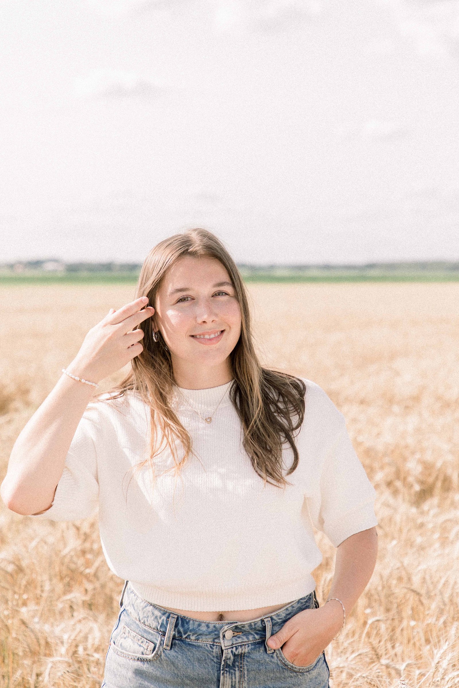 Photo of a woman standing in a wheat field in Rigaud, Quebec. Emily VanderBeek Photography. Montreal Photographer. Light & Airy photographer.