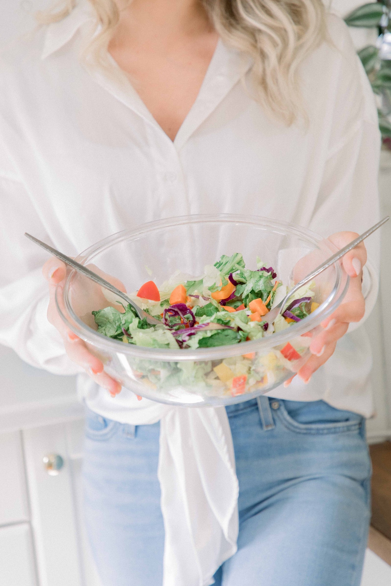 Portrait of a woman holding a salad in a studio kitchen. Light and airy photography. Emily VanderBeek Photography. Niagara Photographer, Ottawa Photographer, Montreal Photographer.